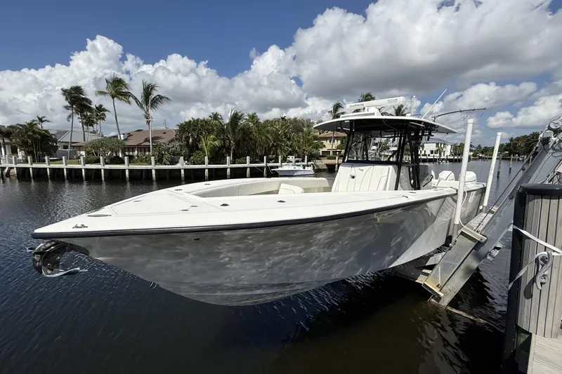 Slide: The Image of 2021 SeaVee 37 boat docked by a scenic waterfront with palm trees. - 5