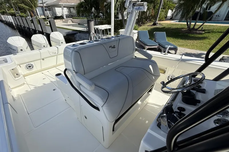 Slide: The Image of 2021 SeaVee 37 boat interior with helm, seating, and Mercury engines docked by waterfront. - 9