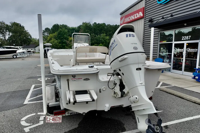 Slide: The Image of 2016 Carolina Skiff Standard 2180 boat with Suzuki outboard motor in dealership parking lot. - 11