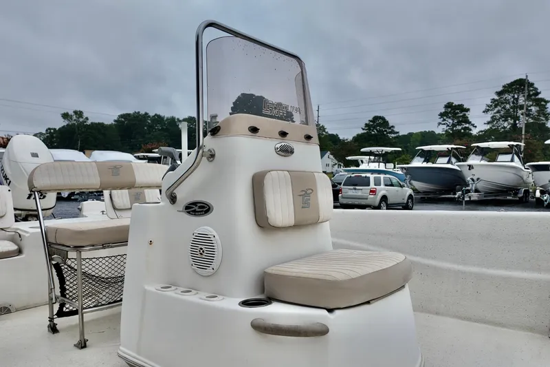 Slide: The Image of 2016 Carolina Skiff Standard 2180 boat interior with seating and console, parked outdoors. - 3