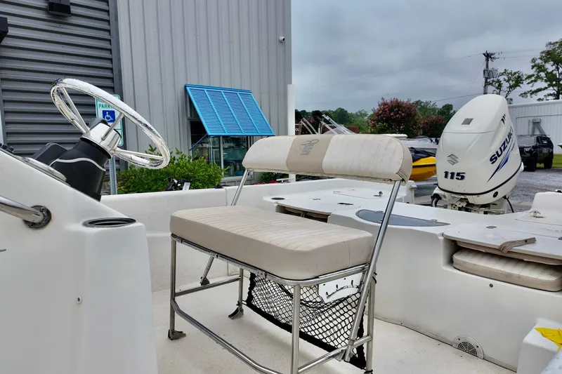 Slide: The Image of 2016 Carolina Skiff Standard 2180 boat with Suzuki 115 outboard motor, parked outdoors. - 7