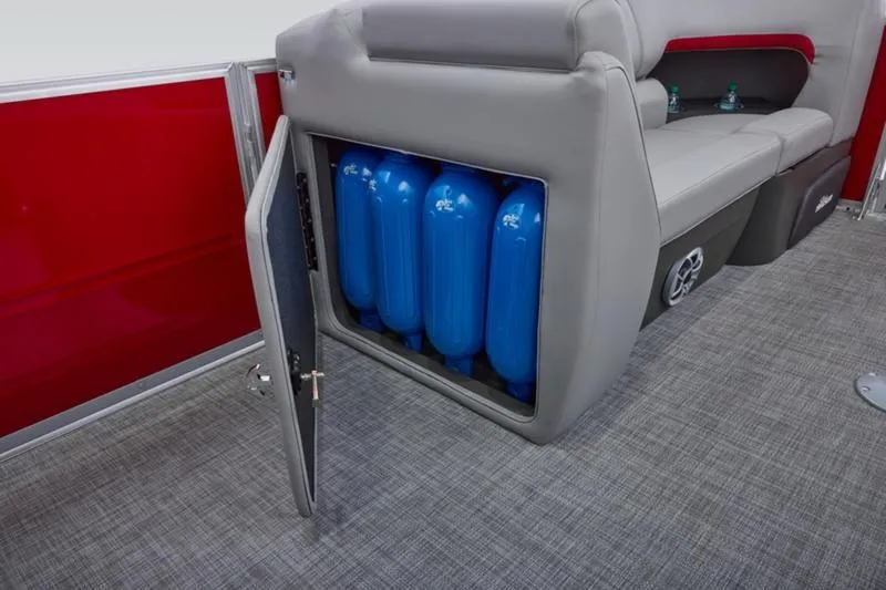 Slide: The Image of 2026 Sun Tracker Party Barge 22 DLX interior storage with blue tanks and gray seating. - 23