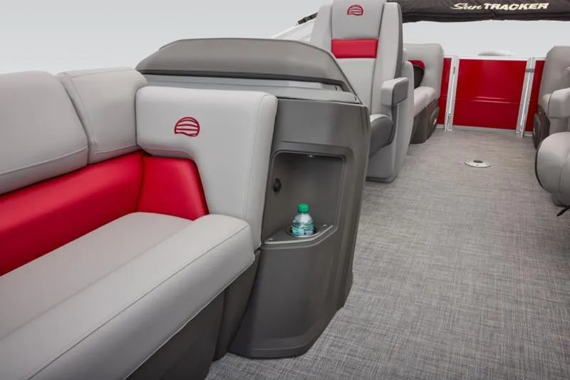 Slide: The Image of 2026 Sun Tracker Party Barge 22 DLX interior with gray and red seating, cup holder, and carpeted floor. - 34