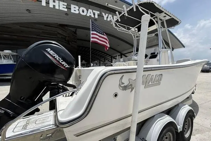 Slide: The Image of 2020 Mako 214 CC boat with Mercury engine at The Boat Yard, American flag visible. - 3