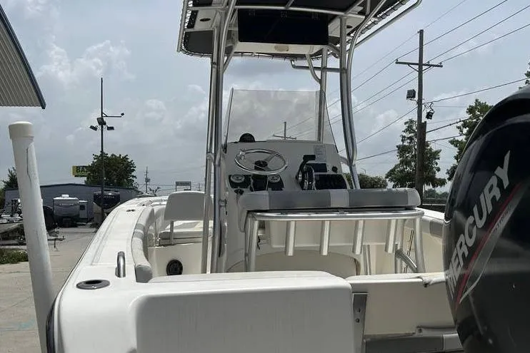 Slide: The Image of 2020 Mako 214 CC boat with Mercury engine, docked outdoors under cloudy sky. - 5