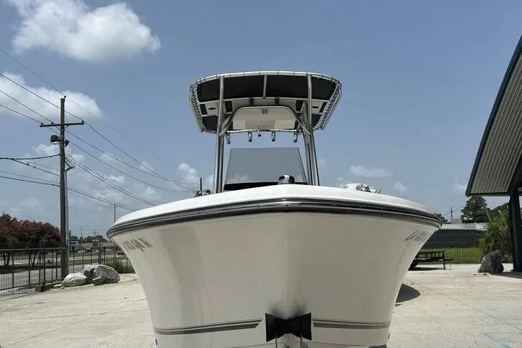 Slide: The Image of 2020 Mako 214 CC boat, front view, parked outdoors under clear sky. - 6