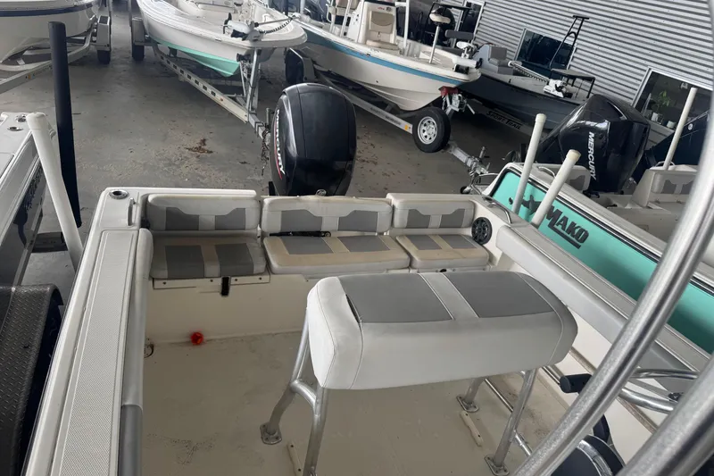 Slide: The Image of 2020 Mako 214 CC boat interior with seating and Mercury outboard motor in storage. - 7