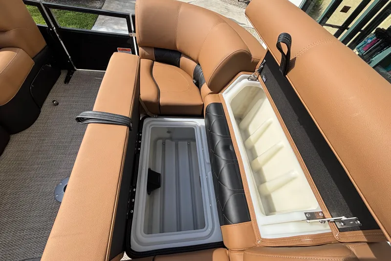 Slide: The Image of 2025 Regency 250 LE3 Sport boat interior with tan leather seats and built-in cooler. - 16
