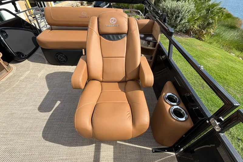 Slide: The Image of Luxurious seating on 2025 Regency 250 LE3 Sport boat, featuring tan leather and cup holders. - 10