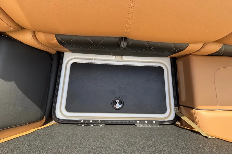 Slide: The Image of Under-seat storage compartment in 2025 Regency 250 LE3 Sport boat, featuring tan and black upholstery. - 13