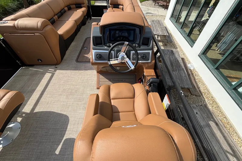 Slide: The Image of 2025 Regency 250 LE3 Sport boat interior with tan leather seating and modern dashboard. - 11