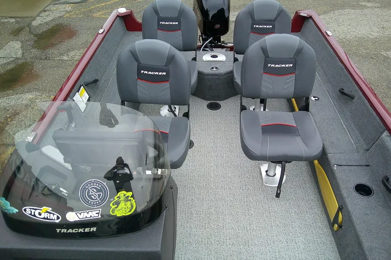 Slide: The Image of 2023 Tracker Pro Guide V-16 SC boat interior with four gray seats and windshield decals. - 53
