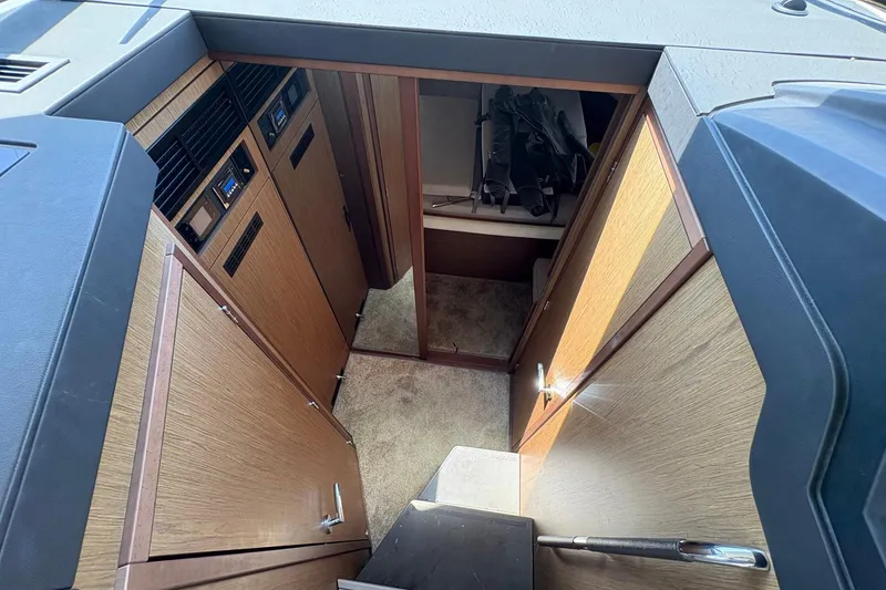 Slide: The Image of Interior view of 2019 Jeanneau NC 33 boat, featuring wooden cabinetry and carpeted flooring. - 12