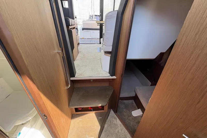 Slide: The Image of Interior view of 2019 Jeanneau NC 33 yacht, featuring wood paneling and carpeted steps. - 13