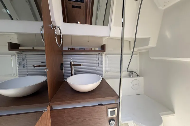 Slide: The Image of 2019 Jeanneau NC 33 bathroom with modern sink, mirror, and wooden cabinetry. - 14