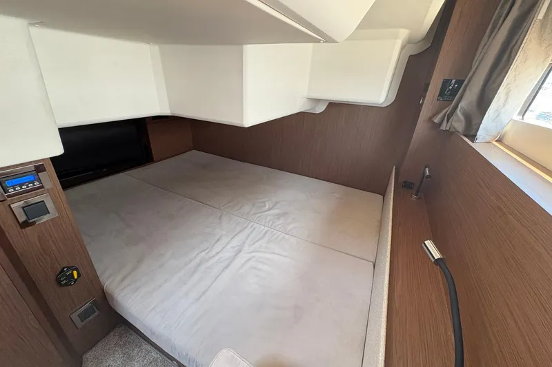 Slide: The Image of 2019 Jeanneau NC 33 cabin interior with cozy bed and modern wood paneling. - 15