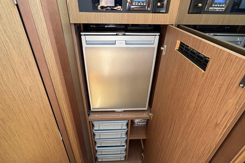 Slide: The Image of Compact kitchen area in 2019 Jeanneau NC 33 boat with fridge and storage drawers. - 16