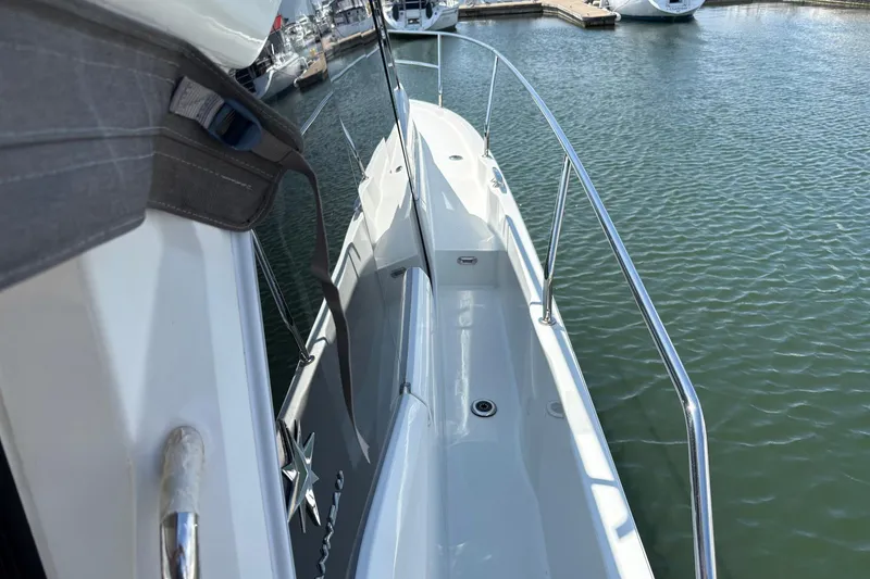 Slide: The Image of 2019 Jeanneau NC 33 yacht docked, showcasing sleek deck and railing design. - 20