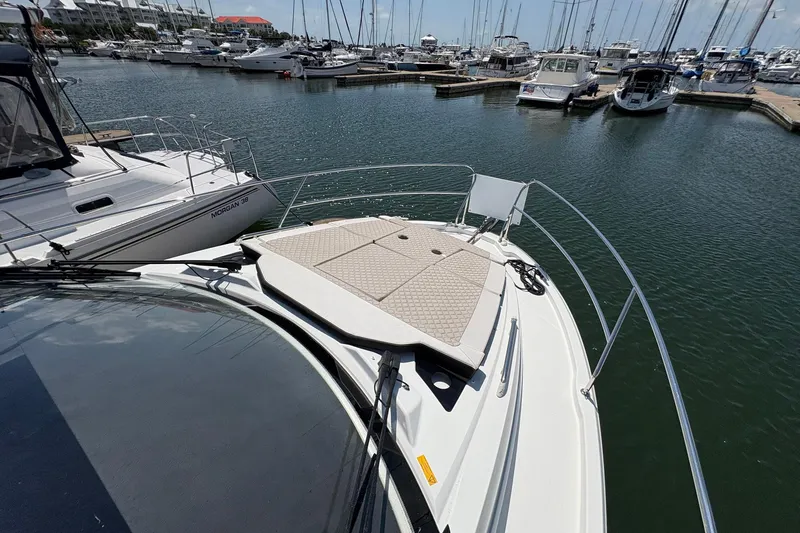 Slide: The Image of 2019 Jeanneau NC 33 yacht docked in a marina, surrounded by other boats. - 21