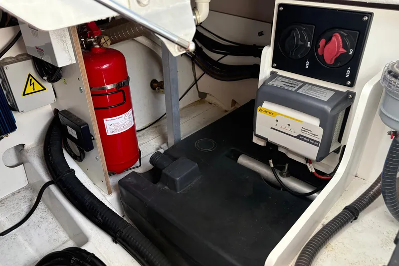Slide: The Image of Engine compartment of 2019 Jeanneau NC 33 with fire extinguisher and electrical components. - 26