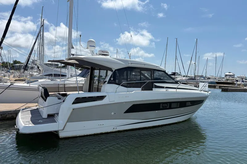 Slide: The Image of 2019 Jeanneau NC 33 yacht docked in a marina under a clear blue sky. - 3