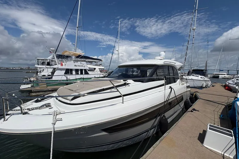 Slide: The Image of 2019 Jeanneau NC 33 yacht docked at marina under blue sky. - 4