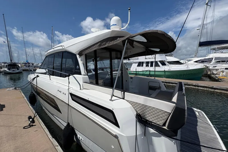 Slide: The Image of 2019 Jeanneau NC 33 yacht docked at marina under clear blue sky. - 5