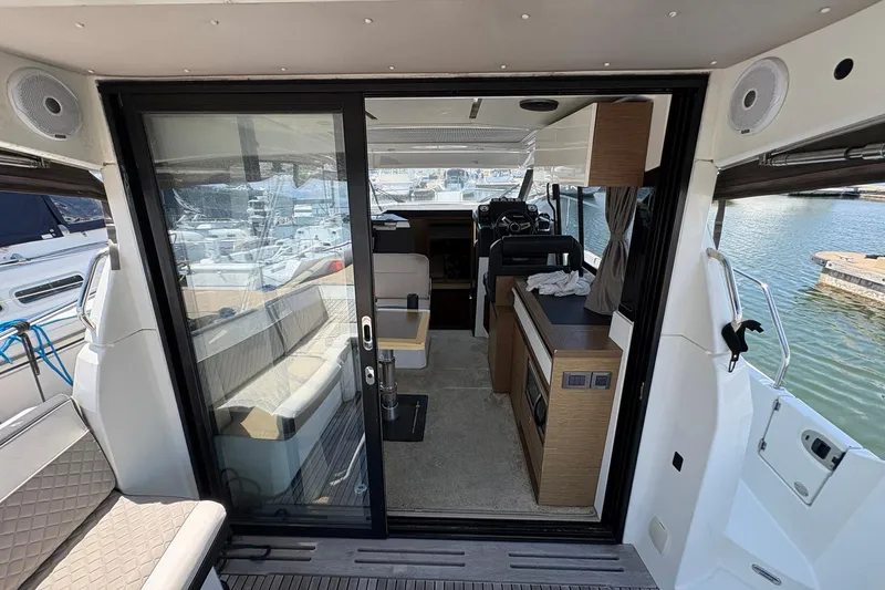 Slide: The Image of Interior view of 2019 Jeanneau NC 33 yacht, featuring modern seating and helm station. - 7
