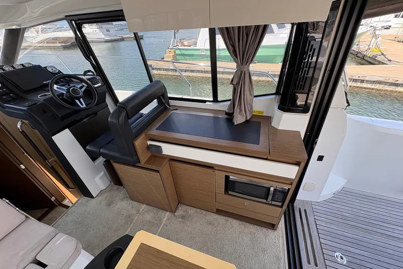 Slide: The Image of Interior of 2019 Jeanneau NC 33 boat with helm, seating, and kitchenette. - 9