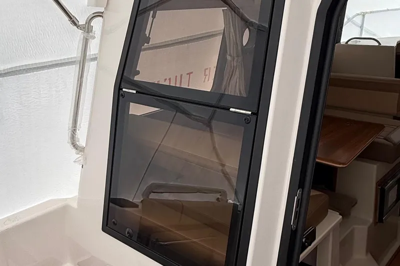 Slide: The Image of 2025 Ranger Tugs R-25 cabin interior with window and seating area. - 10