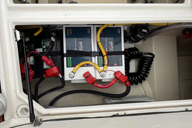 Slide: The Image of Battery compartment of 2025 Ranger Tugs R-25 with connected cables and components. - 18