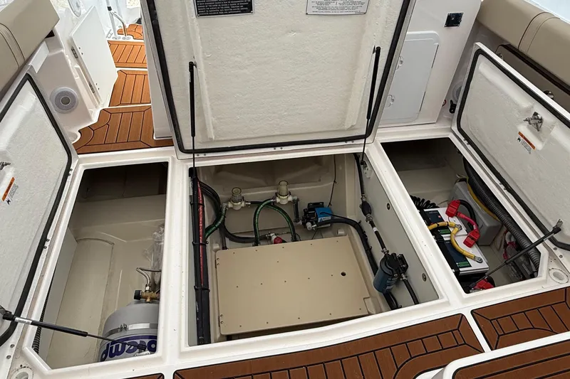 Slide: The Image of 2025 Ranger Tugs R-25 boat interior compartments with open hatches, showcasing storage and equipment. - 19