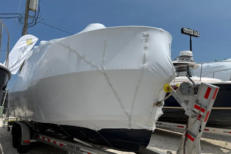 Slide: The Image of 2025 Ranger Tugs R-25 boat wrapped on trailer, parked near Oyster Bar. - 3
