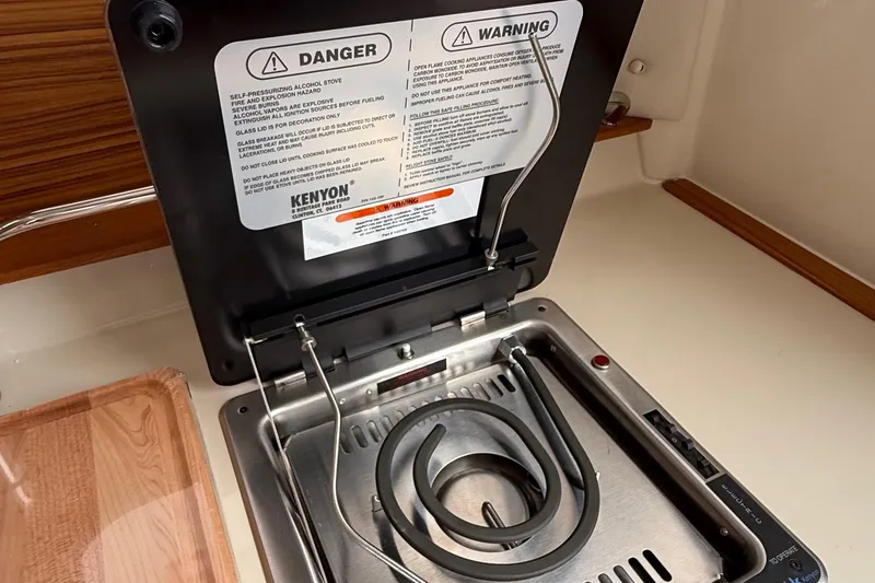 Slide: The Image of Electric stove in 2025 Ranger Tugs R-25 boat galley with safety warnings displayed. - 36