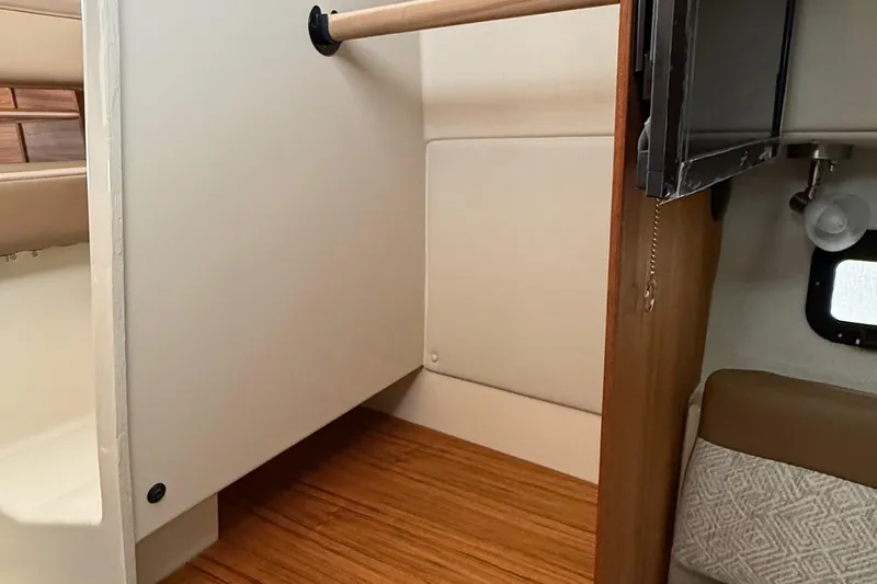 Slide: The Image of Interior of 2025 Ranger Tugs R-25, featuring a compact storage area and wooden flooring. - 42