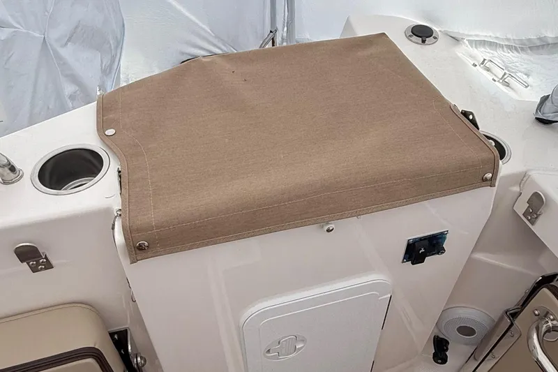 Slide: The Image of 2025 Ranger Tugs R-25 boat interior with covered storage compartment and cup holders. - 5