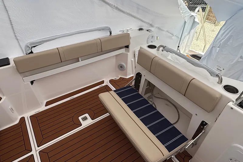 Slide: The Image of 2025 Ranger Tugs R-25 boat interior with cushioned seating and wood-style flooring. - 9