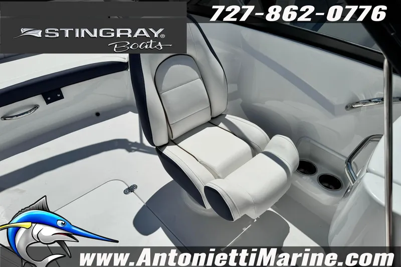 Slide: The Image of 2026 Stingray 191DC Dual Console boat interior with white seating and cup holders. - 17