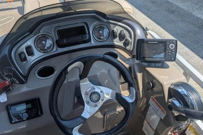 Slide: The Image of 2022 Sun Tracker SportFish 22 DLX dashboard with steering wheel and navigation system. - 2