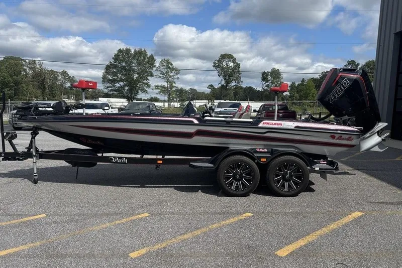 The Image of 2026 Bass Cat Jaguar STS boat on trailer, parked outdoors under cloudy sky. - 0