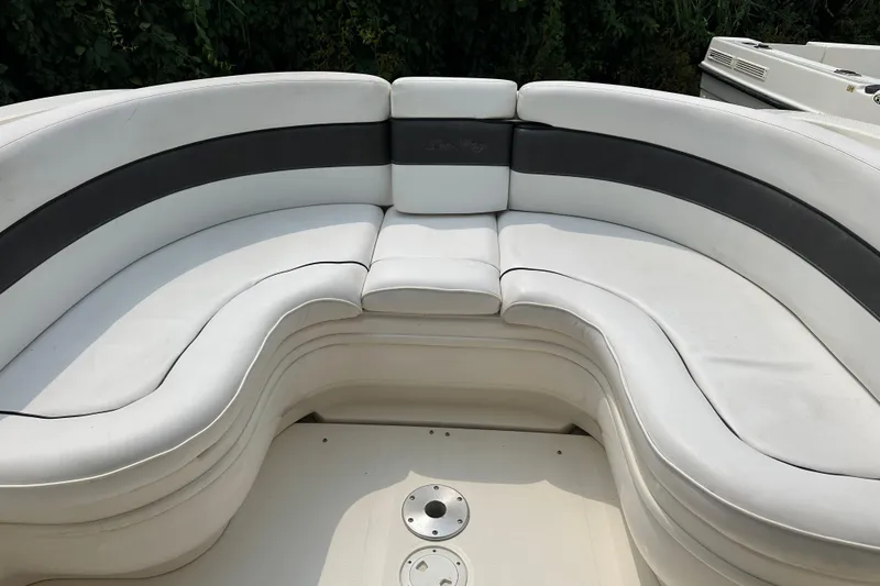 Slide: The Image of 2005 Sea Ray 290 SLX boat with white and gray curved seating area. - 12