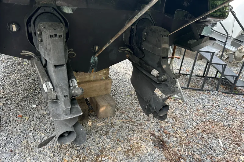 Slide: The Image of 2005 Sea Ray 290 SLX boat outdrives on gravel, supported by wooden blocks. - 16