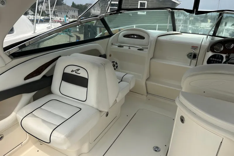 Slide: The Image of 2005 Sea Ray 290 SLX boat interior with white seating and dashboard controls. - 19