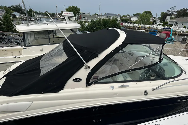 Slide: The Image of 2005 Sea Ray 290 SLX boat with black canopy docked at marina. - 8