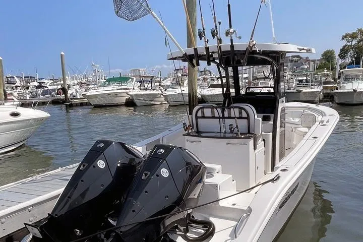 The Image of 2024 Sea Pro 262 DXL boat docked at marina with twin engines and fishing rods. - 0