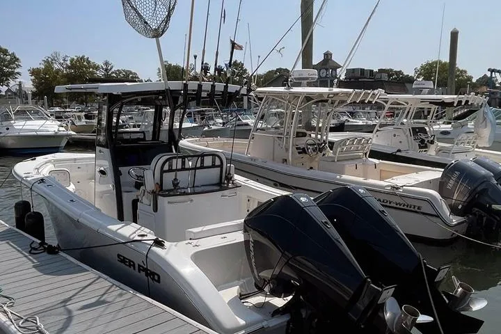 Slide: The Image of 2024 Sea Pro 262 DXL boat docked at marina with other vessels. - 1
