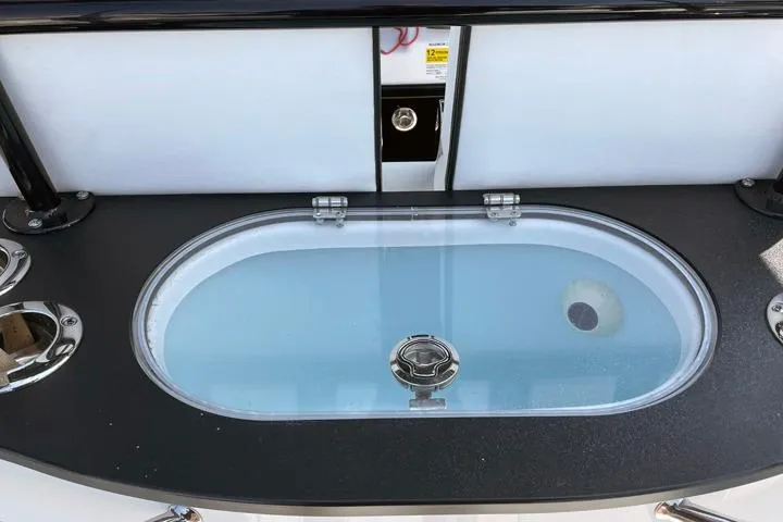 Slide: The Image of 2024 Sea Pro 262 DXL boat livewell with clear lid and black trim. - 12