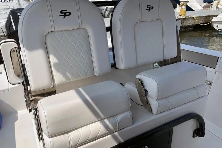 Slide: The Image of 2024 Sea Pro 262 DXL boat seats with white upholstery and diamond stitching. - 2