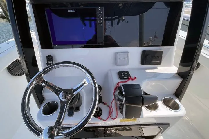 Slide: The Image of 2024 Sea Pro 262 DXL boat dashboard with steering wheel and navigation system. - 3
