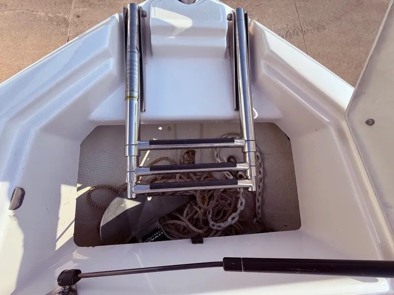 Slide: The Image of 2012 Regal 2700 Bowrider anchor storage with ladder and ropes. - 11